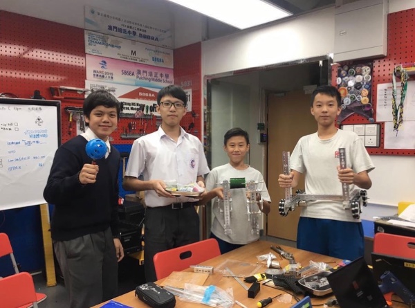 Team members with robot mechanisms in a workshop
